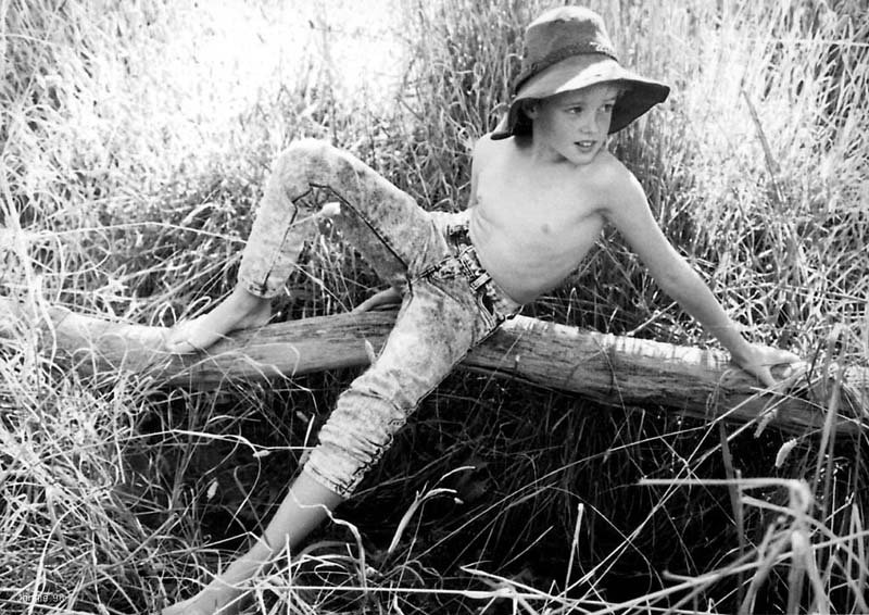 Boy sitting on log